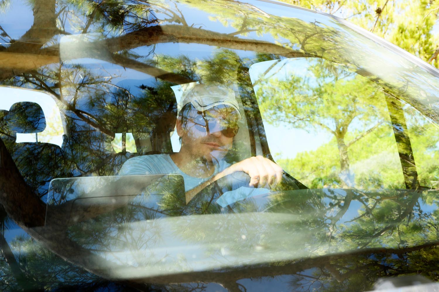 man driving car seen through windshield. solo travels